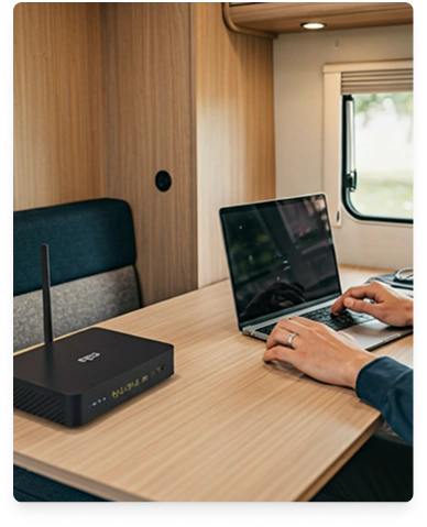 Campervan interior with laptop and router on a table